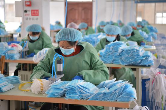 工人在车间加紧赶制口罩