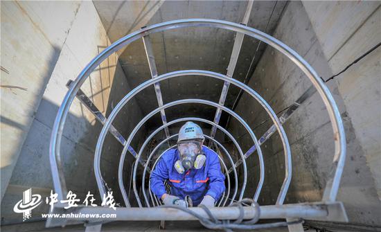 检修员顺着梯子爬进污水井