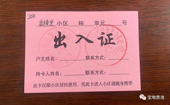 小区大门口向社区居民发放自制的"临时出入证",有了这张简易的通行