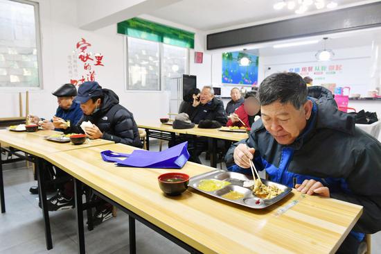 老人使用消毒餐具在"社区大食堂"就餐