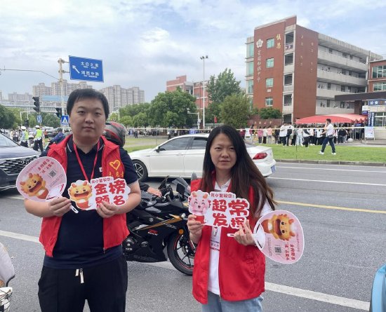 马鞍山新华书店青年突击队队员手举“元小鳌”给考生们送祝福