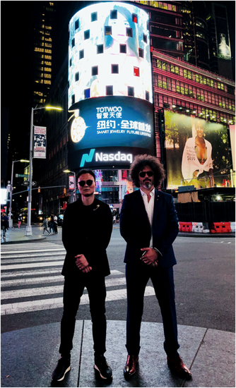 TOTWOO创始人王洁明（左）及联合创始人Marco（右）在 “兔兔智爱天使”登上纽约时代广场大屏下的合照