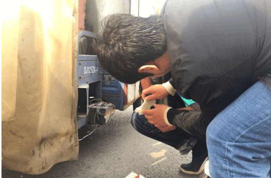 撞车后，三轮车车主头部出血，路过的好心市民递给他纸巾先止血。