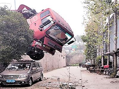 惊险！9米长货车冲出路边 车头悬挂空中