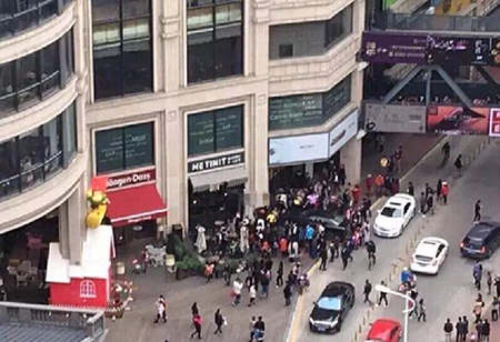 女子误踩油门致车失控 路人被夹车与墙之间