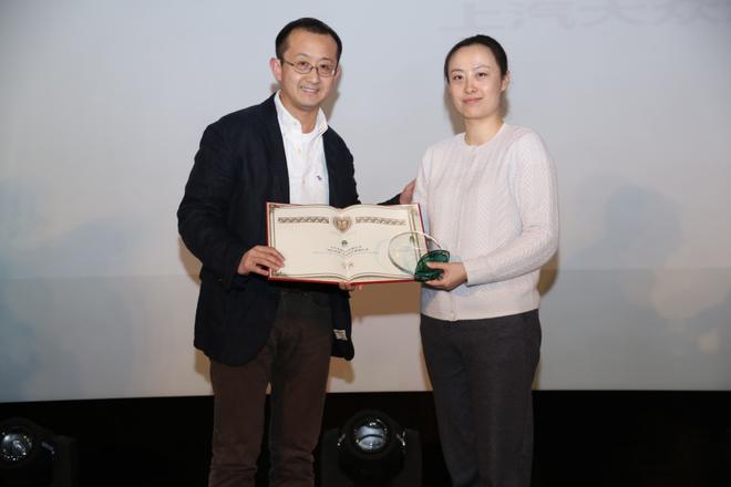 　　▲上汽大众汽车有限公司公关与传播企业品牌传播高级经理刘鸿玉，代表企业领取“益轩奖-2016中国汽车企业社会责任最佳社会关爱公益实践奖”，本瓴才富CEO、雨亭行动创始人翟斌为其颁奖。