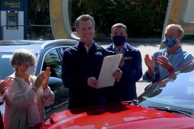 （图：加州州长在一辆福特电动野马Mach-E的引擎盖上签署禁令）
