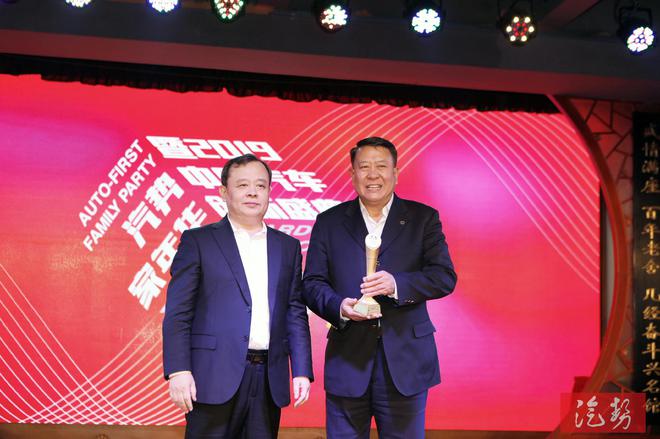 中国贸促会汽车行业分会会长王侠（左）为北汽集团党委书记、董事长徐和谊（右）颁奖