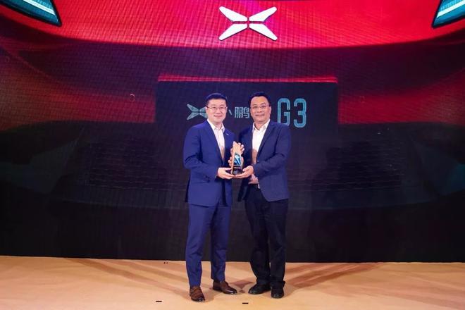 海口市商务局局长蔡俏（右）为小鹏汽车副总裁李鹏程（左）颁奖