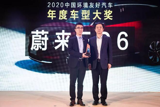中国国际贸易促进委员会汽车行业分会副会长赵扬（右）为蔚来海南城市总经理孔凡品（左）颁奖
