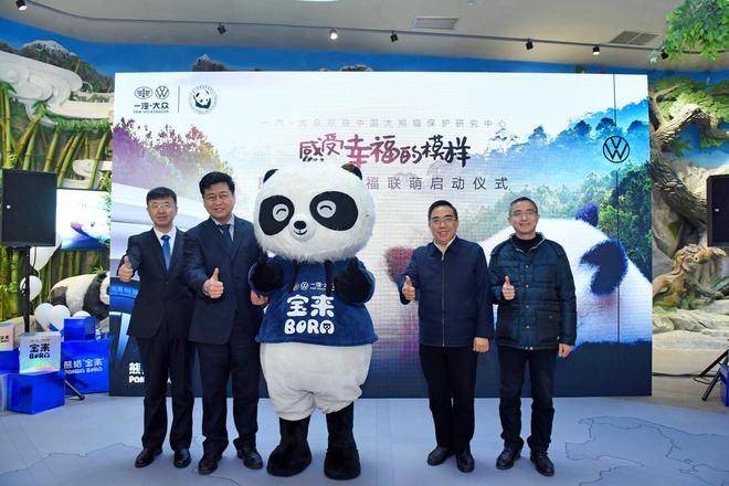一汽-大众销售有限责任公司副总经理 马振山从中国大熊猫保护研究中心常务副主任  张和民手中接过印有“熊猫宝来”掌印的合作授权牌