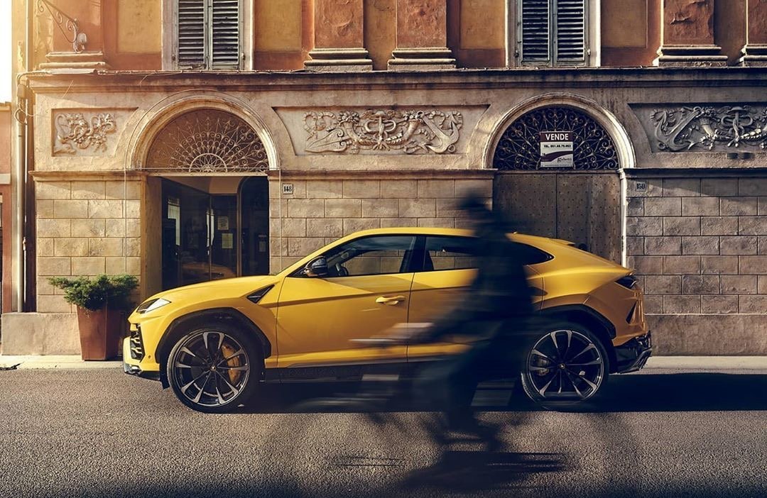 迎着朝阳穿梭在城镇街道的兰博基尼Urus。 美极了！