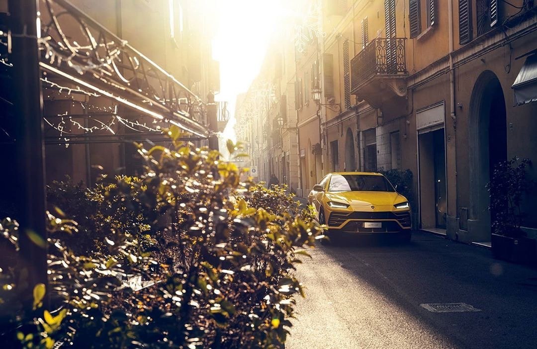 迎着朝阳穿梭在城镇街道的兰博基尼Urus。 美极了！