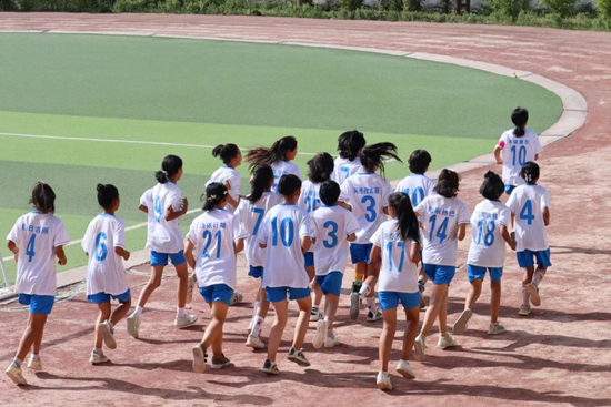 新疆喀什地区巴楚县第三小学女足队在操场上跑步训练。新疆大学 缪文琴/摄新疆