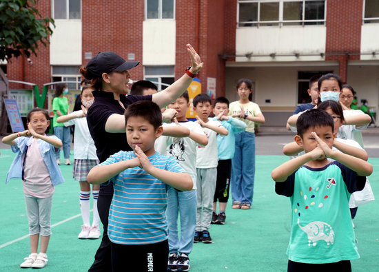 7月5日，在位于上海徐汇区汇师小学分校的爱心暑托班办班点内，小学生在老师指导下练习武术基本动作。新华社记者刘颖 摄