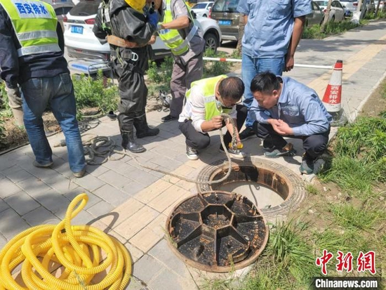 图为检测下水道空气质量，为工作人员搜救做准备。　阿琳娜 摄