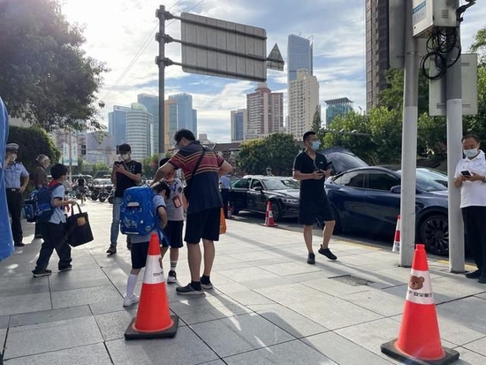 家长在门口送孩子进学校。