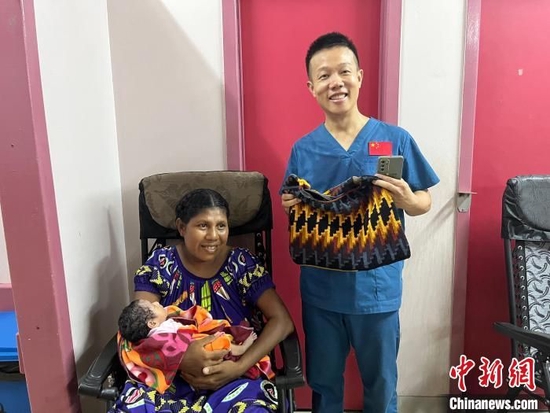 图为孩子妈妈给第12批援巴布亚新几内亚中国医疗队副队长刘振球赠送了一个手工编织包。　受访者供图