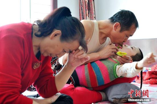 在山西省大同市南郊区马军营乡一栋回迁楼内，54岁的赵玉春将馒头嚼碎后，嘴对嘴喂到女儿口中，像哺育幼鸟一般。这样把食物嚼碎喂到女儿嘴里的动作，赵玉春与妻子李焕梅重复了15年。从弃婴到少女，这个抱养回家的脑瘫女儿就这样被一口一口喂养长大。养母患癌症割舍不下女儿。