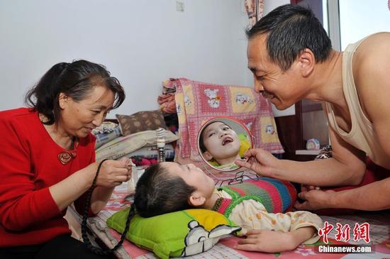 在山西省大同市南郊区马军营乡一栋回迁楼内，54岁的赵玉春将馒头嚼碎后，嘴对嘴喂到女儿口中，像哺育幼鸟一般。这样把食物嚼碎喂到女儿嘴里的动作，赵玉春与妻子李焕梅重复了15年。从弃婴到少女，这个抱养回家的脑瘫女儿就这样被一口一口喂养长大。养母患癌症割舍不下女儿。