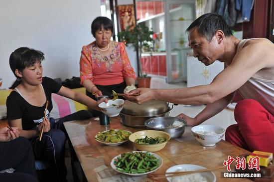 在山西省大同市南郊区马军营乡一栋回迁楼内，54岁的赵玉春将馒头嚼碎后，嘴对嘴喂到女儿口中，像哺育幼鸟一般。这样把食物嚼碎喂到女儿嘴里的动作，赵玉春与妻子李焕梅重复了15年。从弃婴到少女，这个抱养回家的脑瘫女儿就这样被一口一口喂养长大。养母患癌症割舍不下女儿。