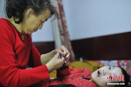 在山西省大同市南郊区马军营乡一栋回迁楼内，54岁的赵玉春将馒头嚼碎后，嘴对嘴喂到女儿口中，像哺育幼鸟一般。这样把食物嚼碎喂到女儿嘴里的动作，赵玉春与妻子李焕梅重复了15年。从弃婴到少女，这个抱养回家的脑瘫女儿就这样被一口一口喂养长大。养母患癌症割舍不下女儿。