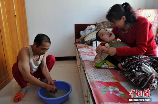 在山西省大同市南郊区马军营乡一栋回迁楼内，54岁的赵玉春将馒头嚼碎后，嘴对嘴喂到女儿口中，像哺育幼鸟一般。这样把食物嚼碎喂到女儿嘴里的动作，赵玉春与妻子李焕梅重复了15年。从弃婴到少女，这个抱养回家的脑瘫女儿就这样被一口一口喂养长大。养母患癌症割舍不下女儿。