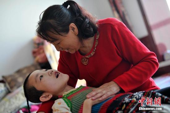 在山西省大同市南郊区马军营乡一栋回迁楼内，54岁的赵玉春将馒头嚼碎后，嘴对嘴喂到女儿口中，像哺育幼鸟一般。这样把食物嚼碎喂到女儿嘴里的动作，赵玉春与妻子李焕梅重复了15年。从弃婴到少女，这个抱养回家的脑瘫女儿就这样被一口一口喂养长大。养母患癌症割舍不下女儿。