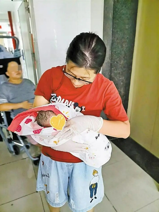 李华燕抱着新生儿准备送医检查其健康状况。受访者供图