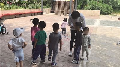 5月10日上午，程琪带家庭托育点的三个孩子到小区“跳房子”，吸引了小区的其他小朋友们一起玩。 新京报记者 李聪 摄