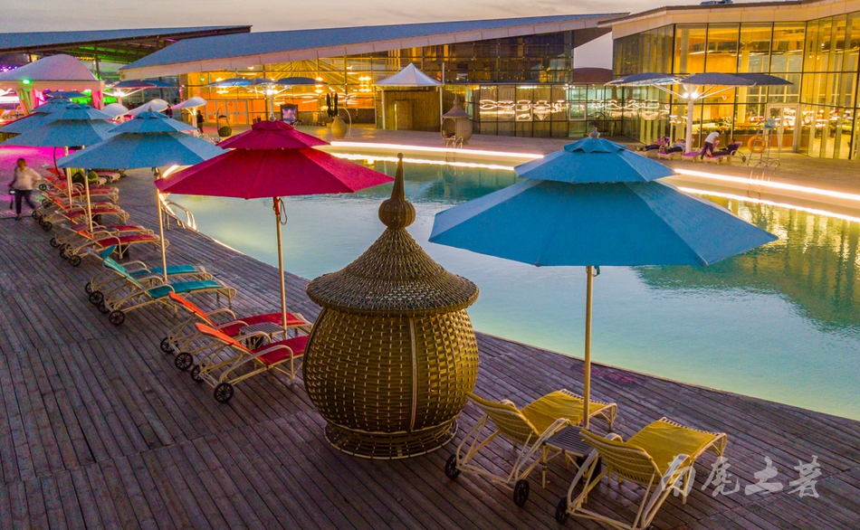 莲花酒店的露天泳池于主楼和裙楼之间,五彩斑斓的阳伞环绕,各种躺椅