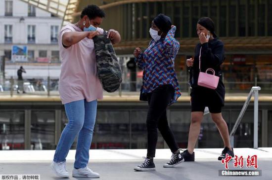 人们戴着防护口罩，走进巴黎的韦斯特菲尔德论坛(Westfield Forum des Halles)购物中心。