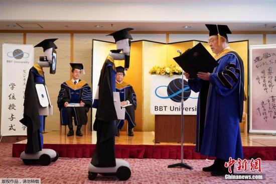  资料图：2020年4月8日，位于日本东京的一所远程教育大学举行毕业典礼，由于受到疫情影响，毕业典礼现场没有学生出现，一款机器人代替学生领取毕业证。