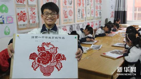 12月7日，河北省临西县第一中学七年级的一名学生在展示自己的剪纸作品。