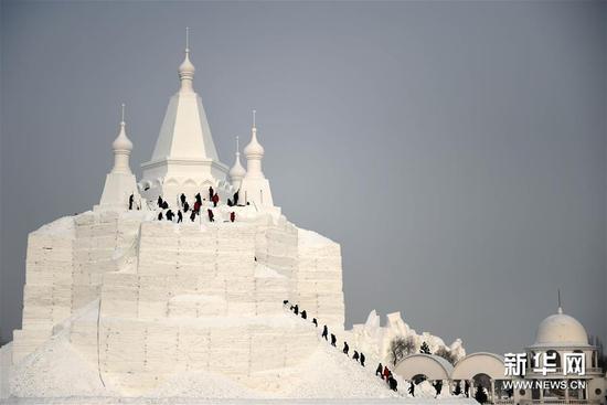 12月22日，在太阳岛雪博会园区，雪雕技师进行大型雪建筑的施工。