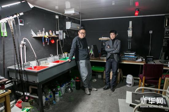 在白夜照相馆内，杨威（左）和王旭在白夜照相馆的暗房中合影（1月10日摄两架）。