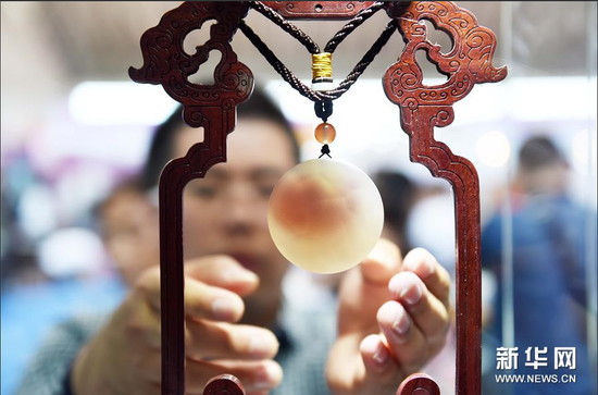 市民在“北红玛瑙”展区观赏玛瑙工艺品