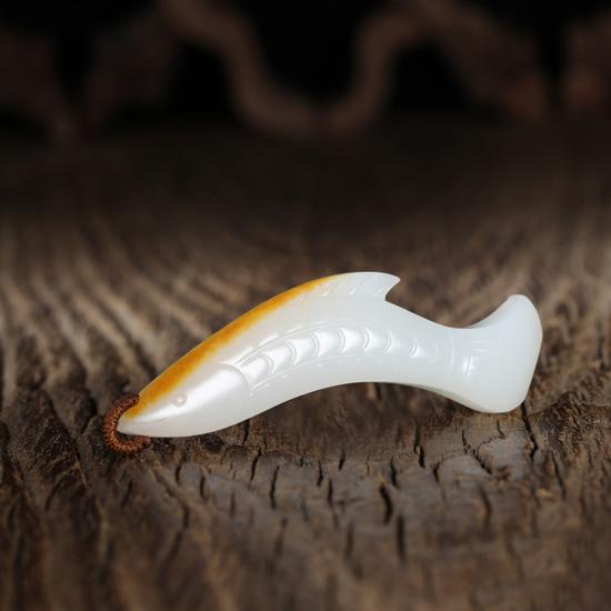 　　02109李剑  中国玉石雕刻大师
和田玉籽料文鱼
规格：6.6×1.5×0.9cm 
重量：17g
白度：标尺
脂份：极高
密度：极好
款识：龙腾、腾
起拍价：无底价
附艺术家证书
