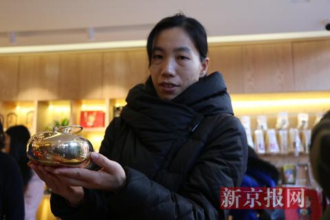 工作人员展示潘家园文创产品汤婆子。实习生 陈婉婷 摄