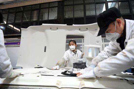 企业佛吉亚(重庆)汽车零部件有限公司重庆工厂的工人在生产车间工作