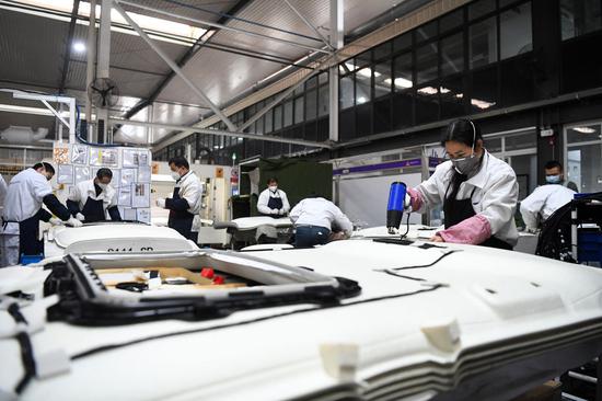 企业佛吉亚(重庆)汽车零部件有限公司重庆工厂的工人在生产车间工作