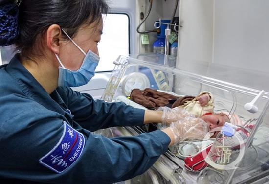 患儿抵达重庆江北机场后,儿童医院医护人员将其抱上救护车放进保温