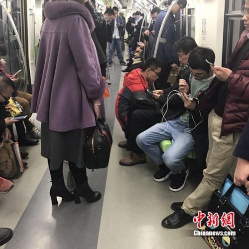 资料图:北京地铁14号线,一些人在低头看手机.张曦 摄