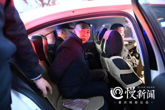 被带上手铐的老赖奉明强被押进法院警车