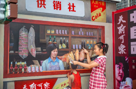 一个小朋友在重庆市南岸区南坪街道正街社区"超级80街"的供销社绘画墙