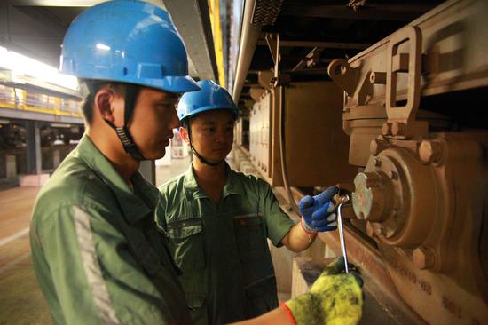 专项修工作人员正在检修车轴,工班长现场抽检