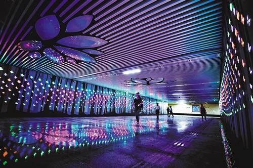 9月12日,九龙坡区华福路,行人从五彩缤纷的美每家地下人行通道内经过.