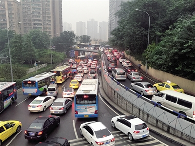 昨日早上,沙坪坝小龙坎转盘,雨中堵车. 本报记者 李斌 摄