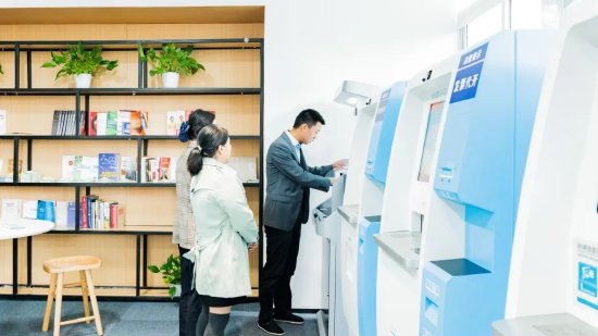 政务惠企E站工作人员细心为企业员工讲解办理事项。(黄维正/摄)