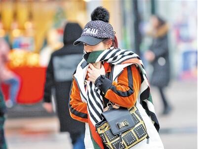 天气寒冷,打扮时髦的美女在寒风里行走.本报记者 高科 摄